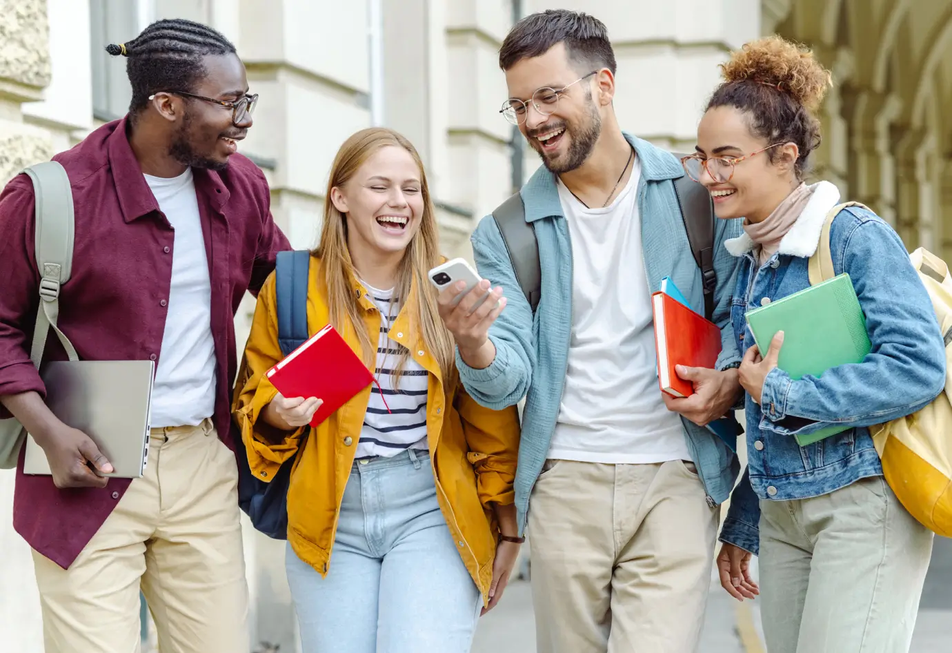 four happy students chatting and walking
