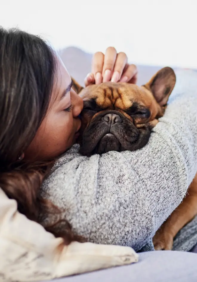 woman cuddling her french bulldog